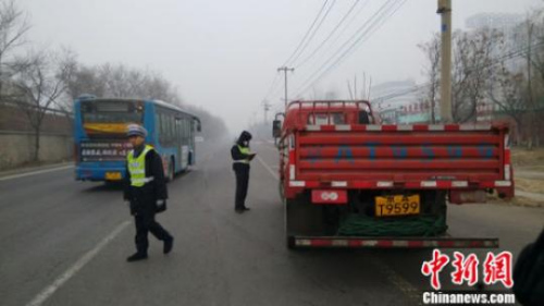 资料图：2015年12月8日下午，京开高速路辅路大庄桥路段，环境监察人员检查路上行驶的大货车。张尼 摄