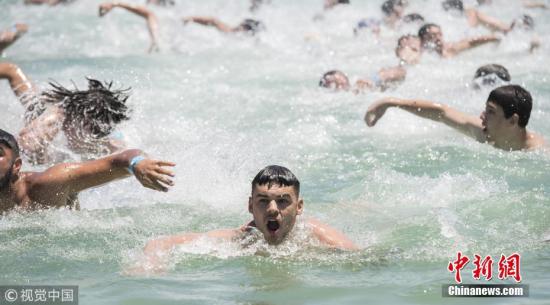 资料图：当地时间1月7日，在悉尼海滩参加游泳比赛的人群。