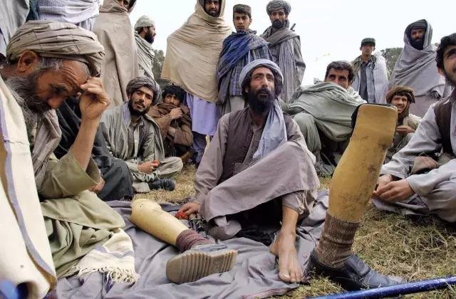 阿富汗男人坐在古尔·阿迦·舍尔扎伊的房子前。